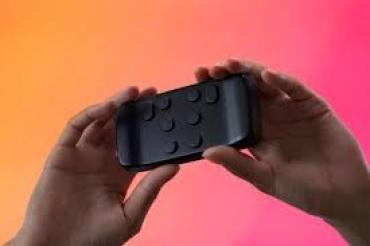 Twee handen houden een brailletoetsenbord ter grootte van een telefoon vast. 